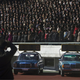 Cars with timing clocks wait for the start of a marathon to begin at Kim Il Sung Stadium.